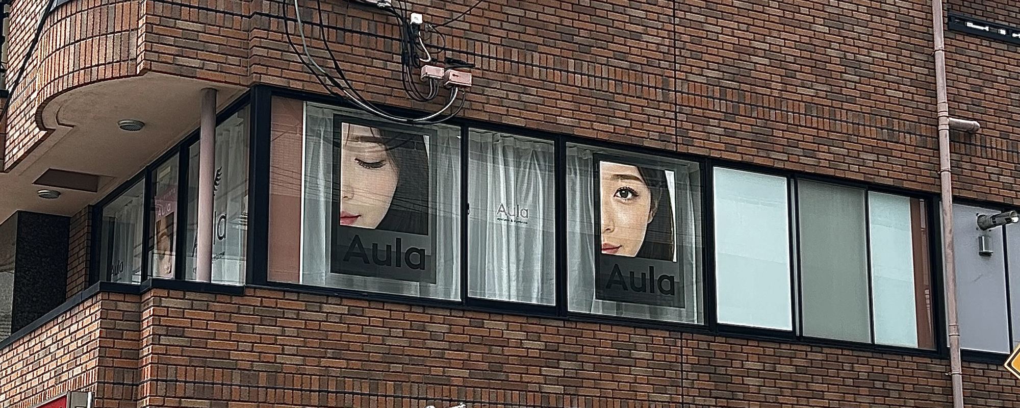 Aulaの外観。レンガ造りのビル2階の窓にAulaのサイン